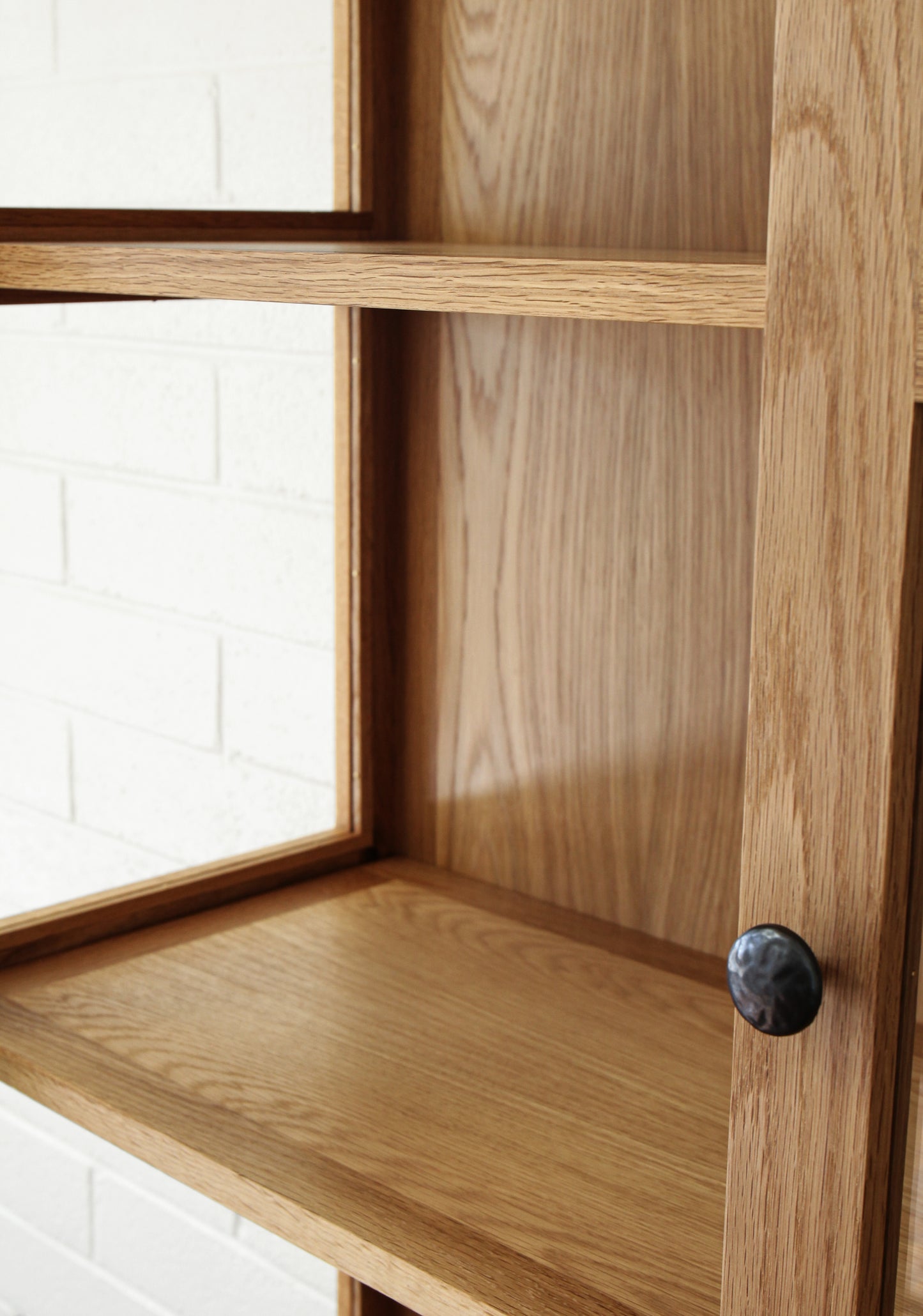 Up close image of interior of white oak display cabinet.